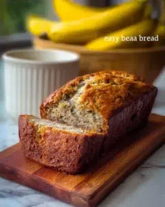Banana Bread 8 Freshly baked banana bread loaf with sliced bananas on a wooden cutting board