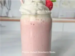 Protein-packed strawberry shake in a glass with fresh strawberries