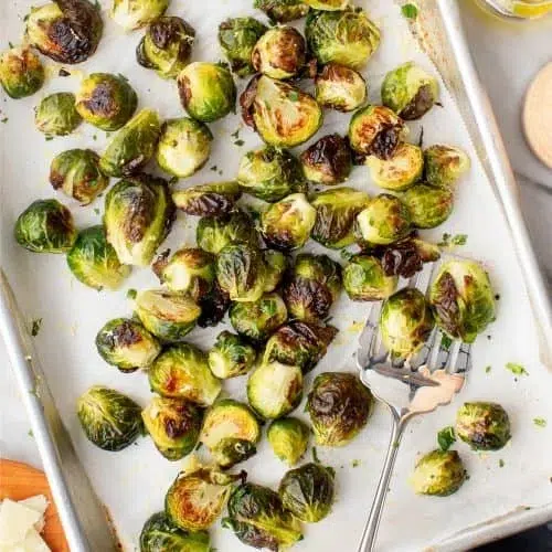 Roasted Brussels Sprouts 1 Oven-roasted Brussels sprouts on a serving plate, crispy and golden brown.