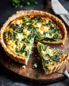 Creamy spinach quiche in a 9-inch pie dish, ready to serve.