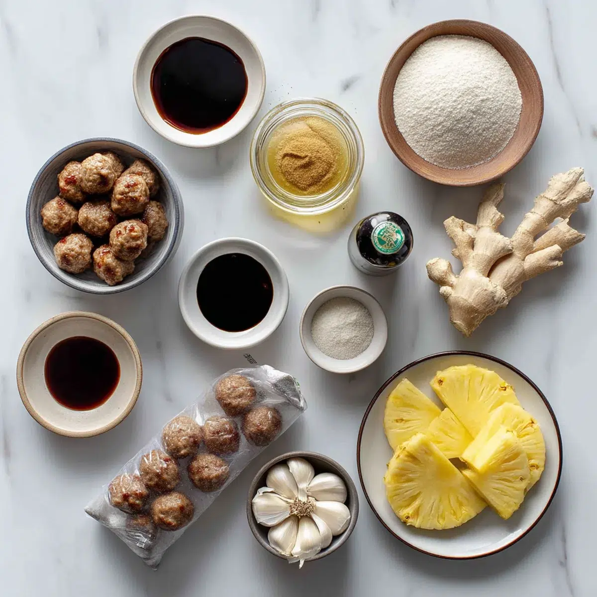 Flat lay of teriyaki meatball ingredients including frozen meatballs, soy sauce, brown sugar, honey, garlic, and ginger