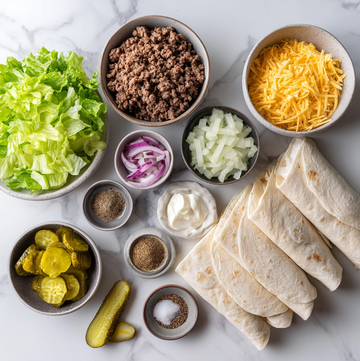big mac wraps recipe ingredients flat-lay with ground beef, flour tortillas, sauce components, and vegetables