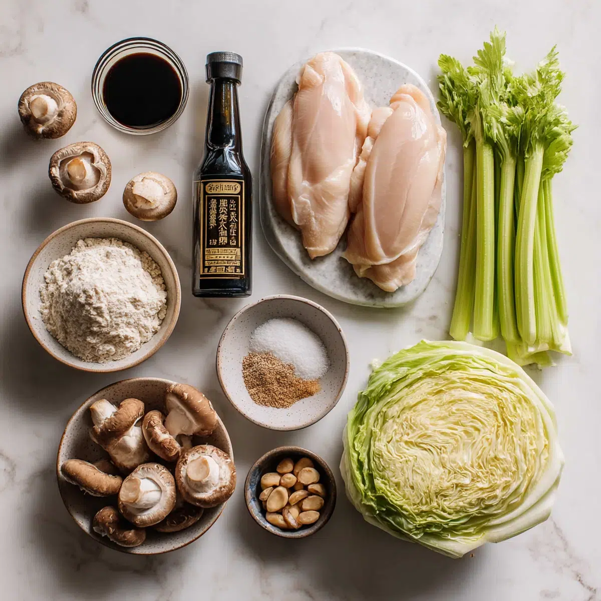 chinese chop suey recipe ingredients flat lay with chicken, celery, napa cabbage, mushrooms, water chestnuts and bamboo shoots