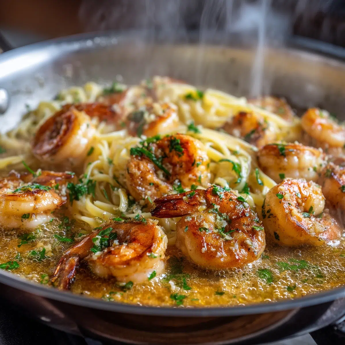 shrimp scampi cooking in a skillet with garlic butter sauce bubbling and shrimp turning pink