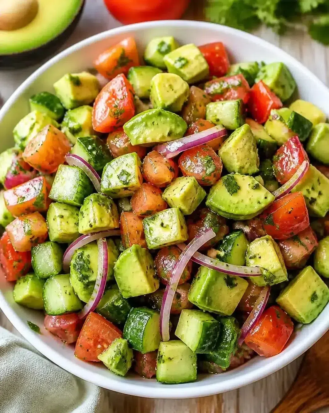 Colorful avocado salad with fresh vegetables and dressing