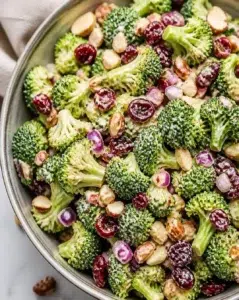 Fresh broccoli salad with vegetables and dressing served in a bowl