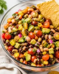 Bowl of colorful Cowboy Caviar salad with black beans, corn, and bell peppers.