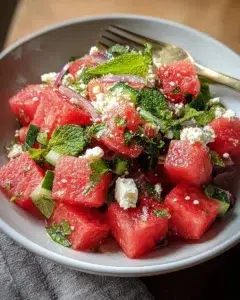 Bowl of refreshing watermelon salad with mint leaves and feta cheese
